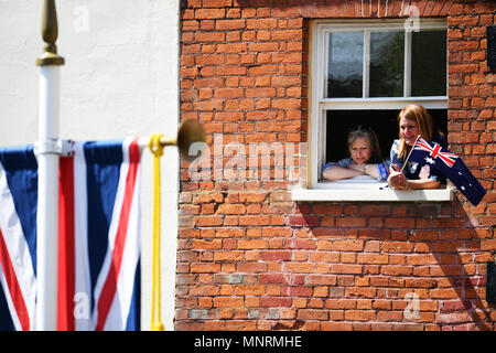 A member of the public holds the Australian flag as she waits for the procession to pass by her window at Cambridge Gate in Windsor, following the wedding of Prince Harry and Meghan Markle at St Geiorge's Chapel in Windsor Castle. Stock Photo