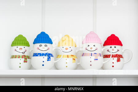 Colorful porcelain mugs with silicone covers on white shelf Stock Photo
