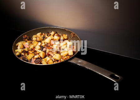 potatoes and sausages called Tiroler Gröstl, in a hot pan Stock Photo