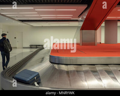 Man walking around baggage claim carousel in empty airport Stock Photo