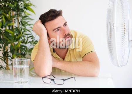 Summer heat. Air conditioning. Young woman cooling down feeling hot sitting  on couch by ventilator at home Stock Photo - Alamy