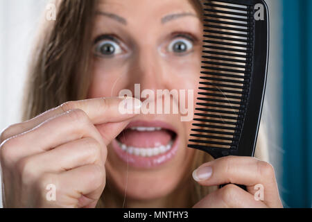 Shocked Woman Suffering From Hair Loss Problem Stock Photo