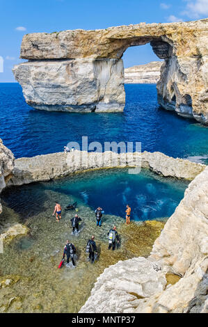 scuba divers and swimmers at Blue Hole, Azure Window, or Dwejra Window in background, Gozo, Malta, Mediterranean Sea, Atlantic Ocean Stock Photo