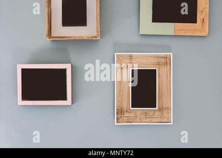Multiple many blank small picture frames on colorful wall Stock Photo