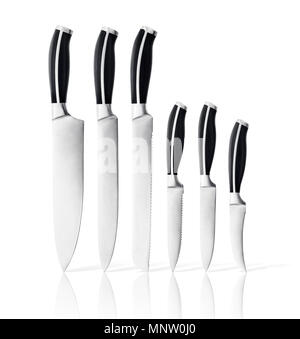 Artistic still life photo of a stainless kitchen knives set standing upright on their tips isolated on white background Stock Photo