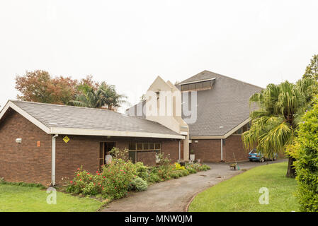 HOWICK, SOUTH AFRICA - MARCH 23, 2018: The Dutch Reformed Church Pietermaritzburg in Merrivale, Howick. Trees, a vehicle and wheelbarrow are visible Stock Photo