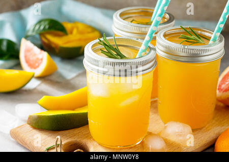 Refreshing summer cocktails made of citrus and mango, cold drink or a drink with ice on a black background. Concept of vegetarian food, fresh vitamins Stock Photo