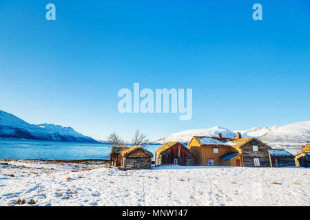 Beautiful winter landscape of Northern Norway with wooden huts overlooking breathtaking fjords scenery Stock Photo