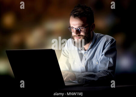 Young handsome businessman working late at night in the office Stock Photo