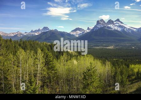 Three Sisters Mountains Scenic Landscape View and Distant Alberta Foothills in Springtime near Banff National Park, Canadian Rocky Mountains Stock Photo