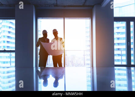Engineer and businessman with plan in empty office Stock Photo