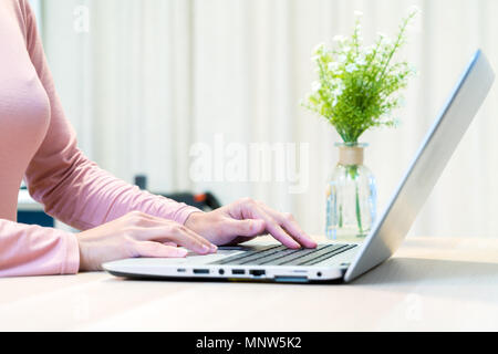 focus on woman hand using laptop, searching, checking, browsing information at home Stock Photo