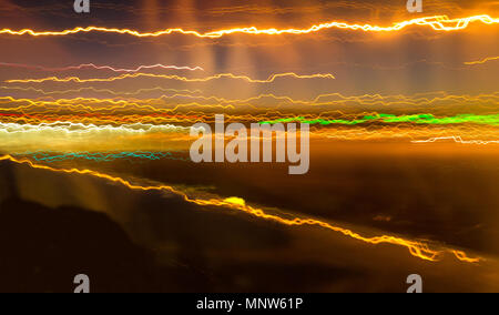 A long exposure from a moving plane transforms airport lights into streaks of colour. Stock Photo