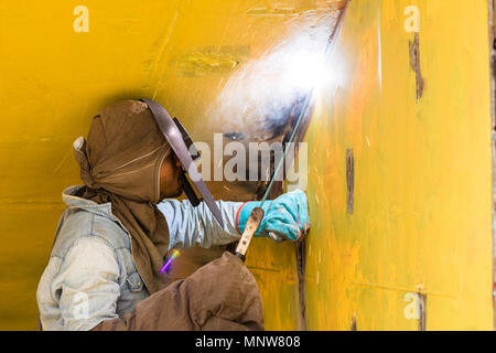 Dhaka, Bangladesh, February 24 2017: Welder on a ship dock on Dhaka Bangladesh welding together two pieces of metal Stock Photo