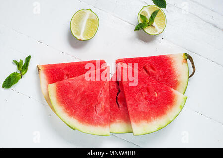 Watermelon slice and lime on rustic wood background. Stock Photo
