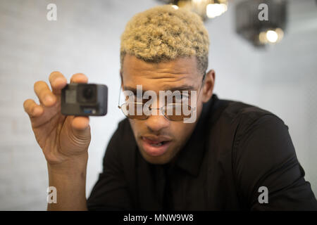 Stylish young man with glasses with camera in hands. Stock Photo