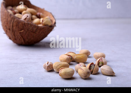 handmade bowl of coconut with pistachios isolated on a white background. Close-up. Stock Photo