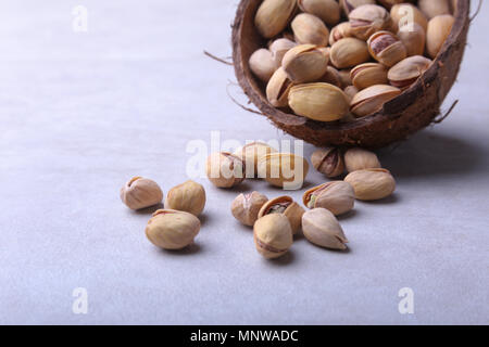 handmade bowl of coconut with pistachios isolated on a white background. Close-up. Stock Photo