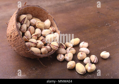 handmade bowl of coconut with pistachios on a stone table. Close-up. Stock Photo