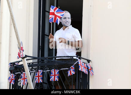 Windsor, UK, 19 May 2018. A person wearing a Prince William, Duke of Cambridge, mask waves his flag from a balcony. Royal Wedding of HRH Prince Harry (of Wales) and Meghan Markle, Windsor, Berkshire, on May 19, 2018. Credit: Paul Marriott/Alamy Live News Stock Photo