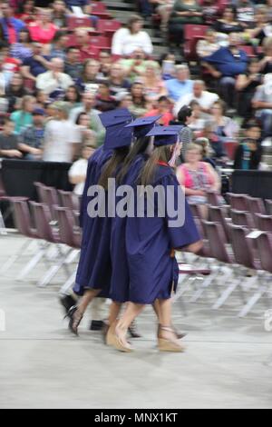 Yakima, Washington / USA - June 13, 2017:  Three Eisenhower High School senior friends walk excitedly to their seats in preparation for their graduati Stock Photo