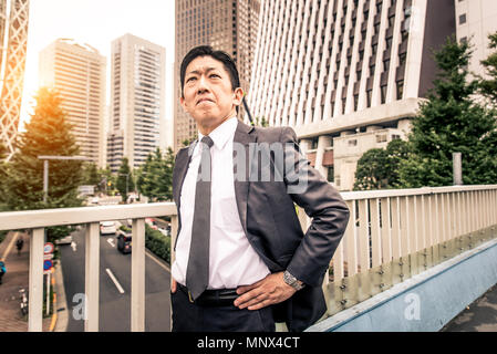 Japanese businessman walking outdoors - Asian man with elegant suit Stock Photo