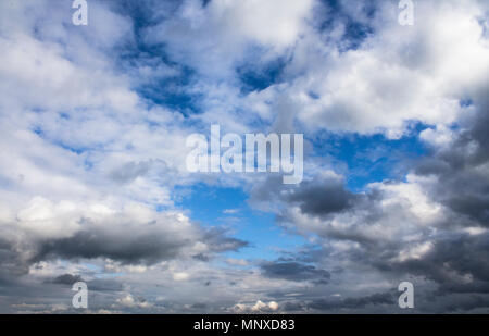 Blue sky background with fluffy cumulus clouds before thunder Stock Photo