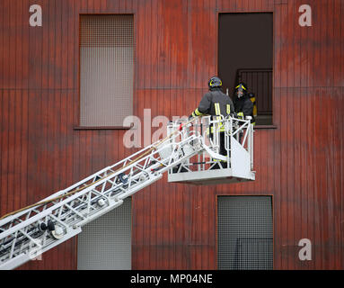 two firefighters in action during a practice at fire barracks Stock Photo