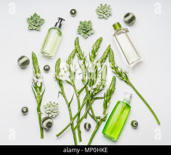 Green herbal natural cosmetic setting with bottles and flowers on white background , top view, flat lay. Beauty and skin care concept Stock Photo