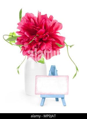 Peony flower in white vase and small easel with paper blank  isolated on white Stock Photo