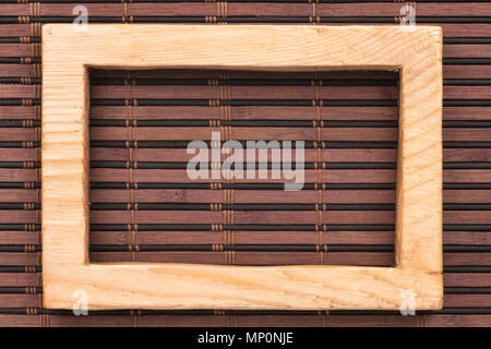 Rectangular wooden frame on a bamboo mat. View from above Stock Photo