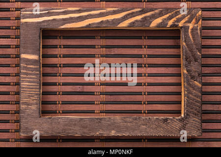 Rectangular wooden frame on a bamboo mat. View from above Stock Photo