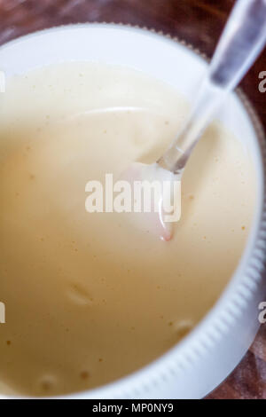 Close up of spatula and whipped cream in bowl on table. Stock Photo