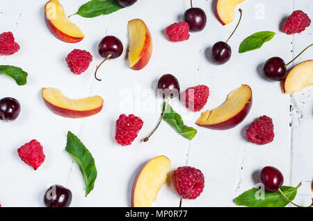 Various types of fruits with green leaves and frozen cocktail with berries on white wood background Stock Photo