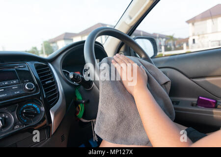 Hands of woman using microfiber fabric to clean up interior of SUV car Stock Photo