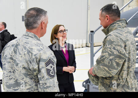 Oregon Governor Kate Brown talks with Chief Master Sgt. Mark McDaniel, 173rd Fighter Wing command chief, and Col. Jeff Smith, 173rd FW commander, during her visit to Kingsley Field in Klamath Falls, Oregon March 13, 2018.  Brown, who traveled to Klamath Falls with Brig. Gen. James Kriesel, Oregon Air National Guard Commander, and Dave Stuckey, Deputy Director, Oregon Military Department, is visiting both the base and community leadership. Stock Photo