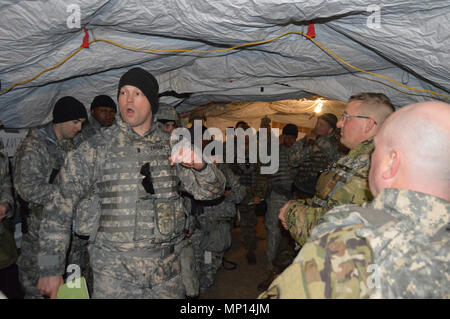 Army Reserve 1st Lt. Christopher Zavesky, an intelligence officer with 348th Transportation Battalion, 90th Sustainment Brigade, 4th Sustainment Command (Expeditionary), based in Houston, Texas, delivers a threat brief in a battalion staff meeting during CSTX 78-18-03, at Fort Story, Virginia, March 13, 2018. CSTX 78-18-03 is a Combat Support Training Exercise that ensures America’s Army Reserve units and Soldiers are trained and ready to deploy on short-notice and bring capable, combat-ready, and lethal firepower in support of the Army and our joint partners anywhere in the world. Stock Photo