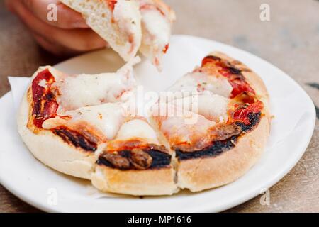 fresh tasty traditional small italian pizza fastfood, eating outside, snack, hands, lifestyle shoot Stock Photo