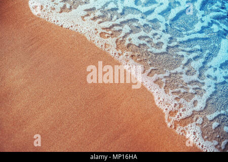 Soft wave of blue ocean on sandy beach. Background. Stock Photo