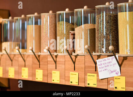 16 May 2018, Germany, Berlin: Different types of grains are offered in dispensers at the zero waste shop 'Der Sache wegen - einfach richtig einkaufen' (lit. For the cause - simply shop right) at Lychener Strasse in the district of Prenzlauber Berg. The shop sells food and household goods like detergents and soap. The products are free of plastic, free of palm-oil, organic, regional, fair, conscious and no animals suffer for them or comply with the current ecological alternative. Food is being sold in reusable containers and filled in own bags, cups or bowls. Among others, this allows for shopp Stock Photo