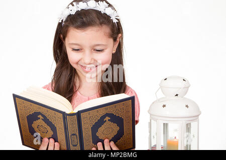 Young Muslim girl reading holy Quran ready for iftar( breakfast ) in Ramadan Stock Photo