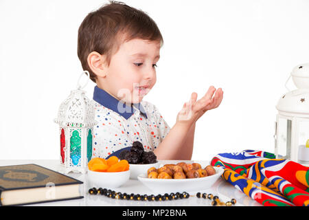 Young Muslim boy praying to Allah while waiting for iftar( breakfast ) in Ramadan Stock Photo