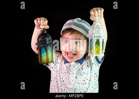 Happy young Muslim child playing with lantern in Ramadan Stock Photo