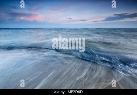 blurred waves on North sea at sunrise Stock Photo