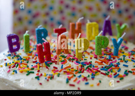 Bright colorful rainbow decorated gifts and cake for 15th birthday celebration. Stock Photo