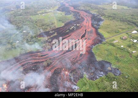 Channelized lava emerges from the elongated fissure 16-20 from the eruption of the Kilauea volcano May 19, 2018 in Pahoa, Hawaii. Stock Photo