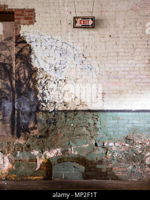 Exit sign on the interior wall of an old factory Stock Photo