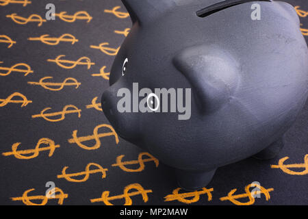 Black piggy bank and dollar signs. Close up. Stock Photo