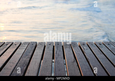 Wooden pier over the beautiful sea at golden hour sunset time. Beautiful view and wood planks floor background. Travel and vacation. Freedom Concept.  Stock Photo
