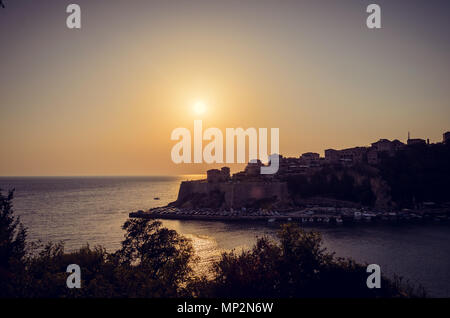 Beautiful sunset view on sea and Stadi Grad - old town of Ulcinj at twilight scene. Coast of Adriatic sea. Montenegro. Stock Photo